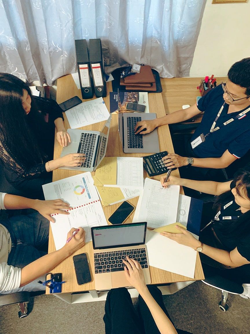 photo of 5 people working on a desk - Myanwei Digital Solutions, Social Media Marketing agency in Yangon