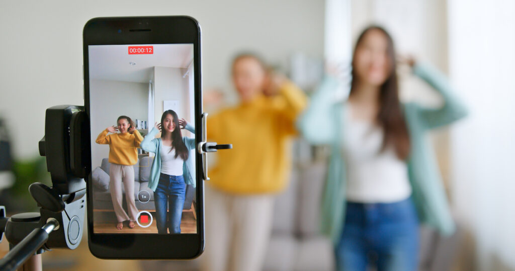 two girl dancing infront of the phone Tik Tok playing